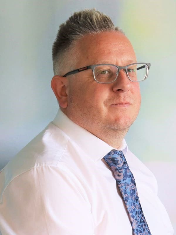 A professional headshot of Neil Chapman-Allen